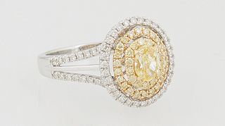 Lady's 18K White Gold Dinner Ring, with an oval .45 ct. fancy yellow diamond, atop a pierced double concentric graduated border of round yellow diamon