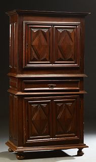 French Louis XIII Style Carved Walnut Homme Debout, 19th c., the stepped dentillated crown over a large cupboard door with applied geometric decoratio
