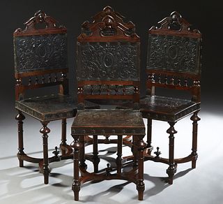 Set of Four French Henri II Style Carved Walnut Side Chairs, c. 1880, the pierce carved crest rail over an embossed leather back above a spindled gall