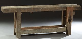 French Provincial Oak Cabinetmaker's Workbench, 19th c., on square legs joined by a lower galleried shelf, with a wood vise on one side, H.- 28 1/4 in