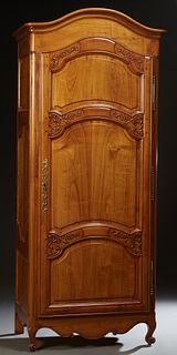 French Provincial Louis XV Style Carved Cherry Bonnetiere, 19th c., the stepped arched crown over a triple fielded panel door with brass fiche hinges 