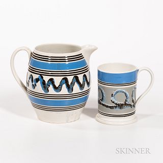 Two Pieces of Slip-decorated Pearlware, England, early 19th century, a large barrel-form jug and a quart mug, both with black bands, wi