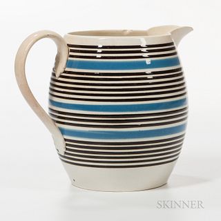 Whiteware Barrel-form Slip-banded Jug, England, c. 1840, decorated with bands of blue and black slip, handle with foliate terminals, ht