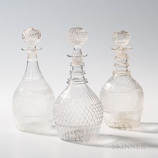 Three Colorless Three-mold Blown Glass Decanters, America, 19th century, of similar form, two with applied rings to the necks, one with
