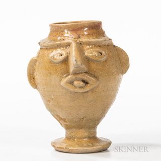 Small Glazed Face Jug, possibly South Carolina, late 19th/early 20th century, the light-bodied clay with cream-colored glaze, ovoid foo