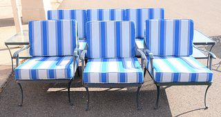 Six piece outdoor lot to include three armchairs, one sofa, and two glass top side tables with cushion.