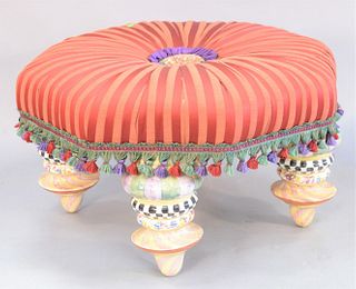 Large red upholstered Mackenzie Childs ottoman, with hand painted ceramic feet, 21" x 33".