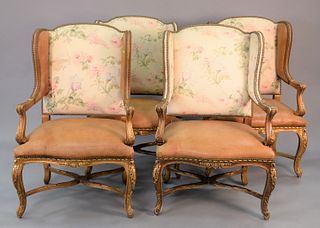 Set of four Ralph Lauren Louis 15th style arm wing chairs, gilt with leather and cloth upholstery, sun fading. 45" x 28 1/2".
