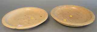 Two early Asian glazed chargers, each having off white crackle glaze, with shallow bowl form and firing marks, one with Chinese marks on the underside