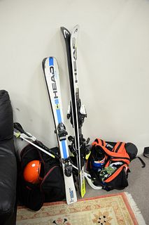 Group of two kids World Cup snow skis, boots, helmets and poles, varying sizes.