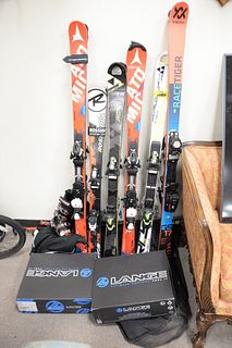 Group of children's snow skis, boots and poles, brands include Atomic, Lange and Fischer, varying sizes.