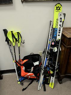 Group of children's snow skis, boots, helmets and poles, sizes vary.