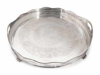 An English Silverplate Two-Handled, Galleried and Footed Circular Tray
Height 3 1/4 inches at handles; diameter 21 3/4 inches.