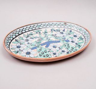 Centro de mesa. México, siglo XX. Diseño oval. Elaborado en mayólica policromada y vidriada. Decorado con pavorreales y otros.