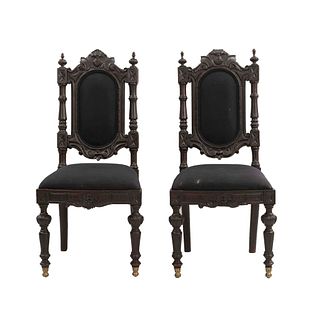 Par de sillas. Siglo XX. Estilo francés. Estructura de madera. Con respaldos semiabiertos, asientos en tapicería color negro.