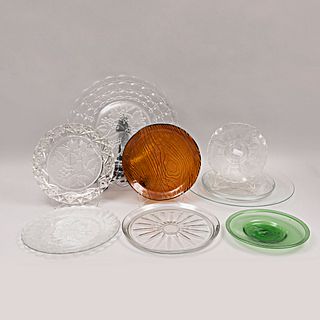 Lote de 10 platones. Diferentes orígenes y diseños. Siglo XX. Elaborados en vidrio. Decorados con elementos vegetales.