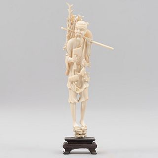 Leñador. China, siglo XX. Talla en marfil. Con hacha, sombrero, ramas y base de madera. 25 cm.