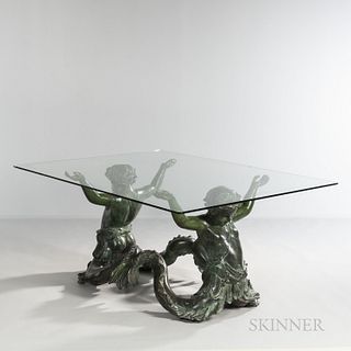 Bronze Putti de Mare and Glass Table, Italy, c. 1960, the figural base depicting a pair of aquatic figures with outstretched arms suppo