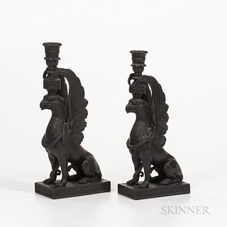 Two Wedgwood Black Basalt Griffin Candlesticks, England, late 19th century, each modeled seated and supporting a candle nozzle, impress