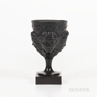 Humphrey Palmer Black Basalt Goblet, England, c. 1775, molded cup with four faces below a heart-shaped leaf vine with simple socle and