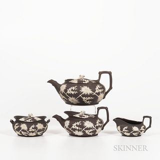 Four Wedgwood Dark Brown Stoneware Prunus Tea Wares, England, early 19th century, each oval shape and with white prunus decoration, inc