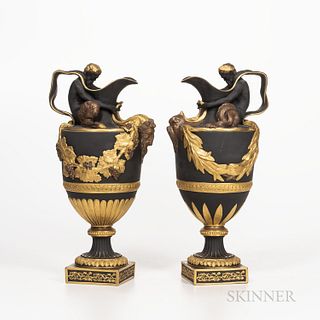Pair of Wedgwood Gilded and Bronzed Black Basalt Wine and Water Ewers, England, late 19th century, the water ewer with a figure of Trit