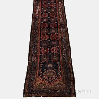 Malayer Runner, Iran, c. 1920, featuring a dark blue field with stylized palmettes, 14 ft. 2 in. x 3 ft. 3 in.