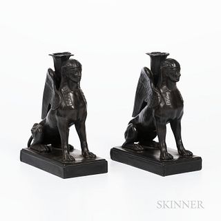 Pair of Wedgwood Black Basalt Seated Sphinx Candleholders, England, each modeled with a foliate molded candle nozzle set between their