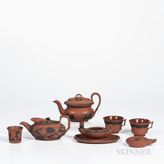 Seven Wedgwood Rosso Antico Items, England, 19th century, each with applied black basalt relief, including a prunus decorated parapet t