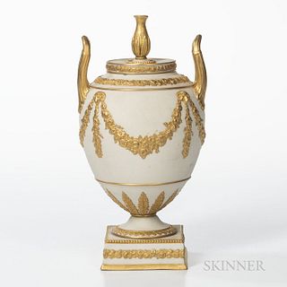 Wedgwood Gilded White Stoneware Vase and Cover, England, 19th century, urn finial and upturned loop handle, ovoid shape body with flora
