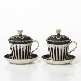 Two Wedgwood Black Jasper Dip Covered Cups and Saucers, England, 19th century, engine-turned striping and with applied white floral fin