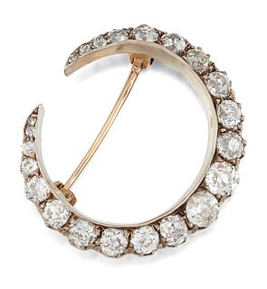 A DIAMOND CRESCENT BROOCH, the crescent set with graduated 