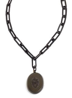 A VICTORIAN JET PENDANT AND CHAIN, the oval jet locket with