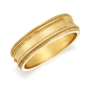 A 15 CARAT GOLD ETRUSCAN REVIVAL BANGLE, the broad hinged b