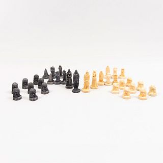 Figuras de ajedrez, apaches vs peregrinos. Siglo XX. Elaboradas en pasta moldeada. Acabado crudo y color negro. Con estuche.