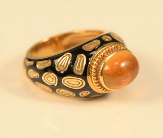 18K gold, black enamel, and cabochon citrine ring, centering one oval cabochon citrine, flanked by black enamel with decorative gold swirls, signed 'M