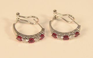 Pair 14K white gold pierced earrings mounted with two diamonds and three red stones each, 5.9 gr., diamonds approximately .20 cts each, total .80 cts.