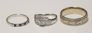 Three rings, one diamond ring set with 14 diamonds surrounding a center diamond 4.8mm, approximately quarter carat ring cut, plus man's 14k band and 1