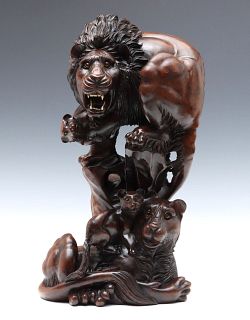 A DRAMATIC CARVED WOOD GROUPING OF GLASS-EYED LIONS