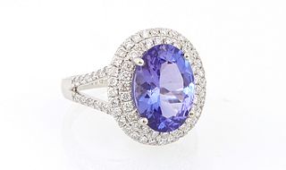 Lady's Platinum Dinner Ring, with an oval 3.88 ct. tanzanite atop a double graduated concentric border of tiny round diamonds, the s...