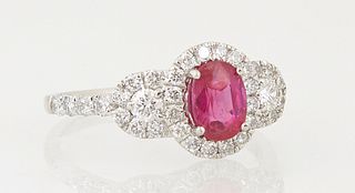 Lady's Platinum Dinner Ring, with an rare unheated oval 1.05 ct. ruby, atop a border of round diamonds, flanked by diamond mounted l...