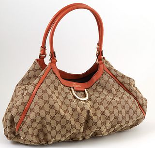 Gucci Burnt Umber Leather and Beige Monogramed Canvas D-Ring Hobo Handbag, the exterior with gold hardware, opening to a brown lined...