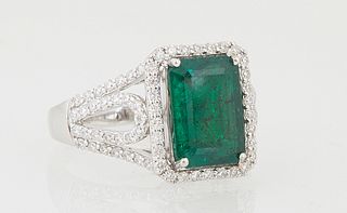 Lady's 14K White Gold Dinner Ring, with a 2.79 ct. rectangular emerald atop a conforming border of round diamonds, the pierced split...