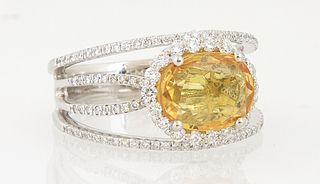 Lady's Platinum Dinner Ring, with an oval horizontal 2.77 ct. yellow sapphire, joining two outer borders of small round diamonds, at...