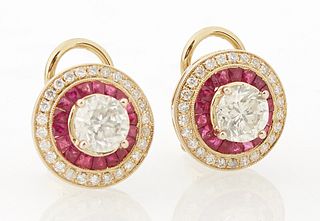 Pair of 14K Yellow Gold Stud Earrings, each with a .98 carat round diamond within a border of ruby baguettes and an outer border of...