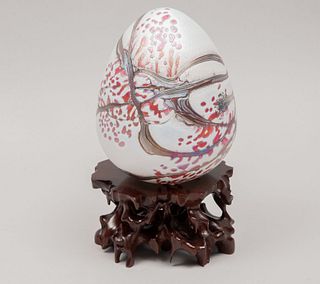 Huevo decorativo. Siglo XX. Elaborado en cristal policromado. Acabado iridiscente. Con base de madera. 16 x 12 cm Ø