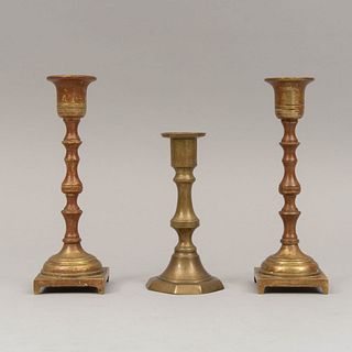 Lote de 3 candeleros. Siglo XX. Elaborados en bronce. Decorados con molduras y elementos geométricos. 17 x 5.5 x 5.5 cm (mayor).