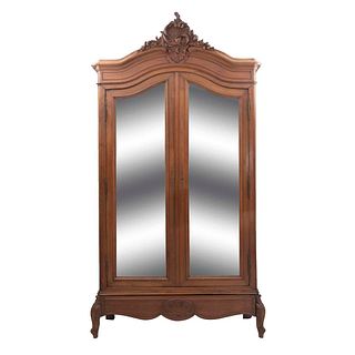 Armario. Francia. Siglo XX. Estilo Luis XV. En talla de madera de nogal. Con 2 puertas abatibles con espejos de lunas irregulares.