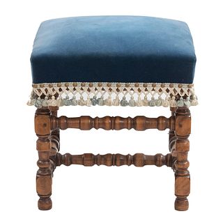 Taburete. Francia. Siglo XX. Estilo Luis XIII. Elaborado en madera tallada de nogal. Con asiento en tapicería color azul.