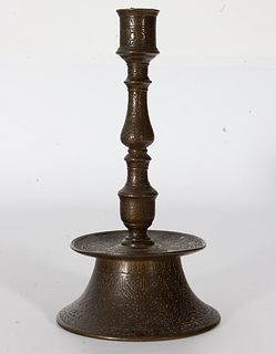 Dos candeleros islámicos en bronce con decoración estilizada, uno con incrustaciones en plata, del siglo XVIII.